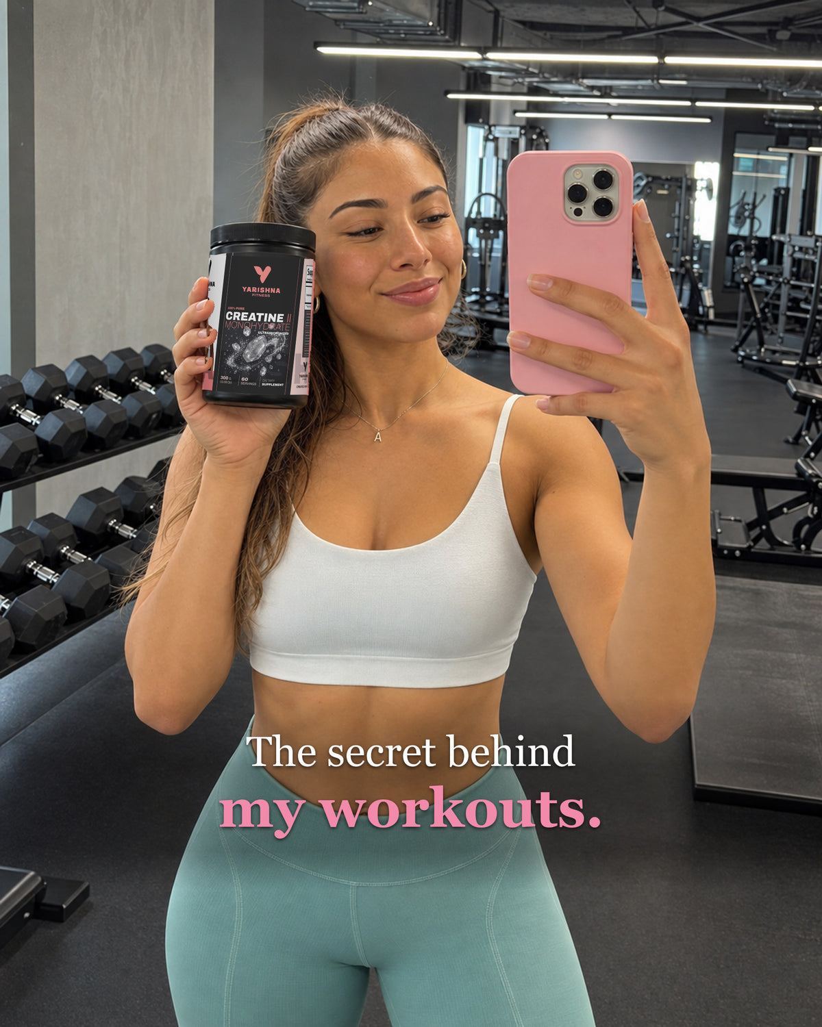 Woman taking a gym mirror selfie holding the Yarishna Fitness 100% Creatine Monohydrate tub