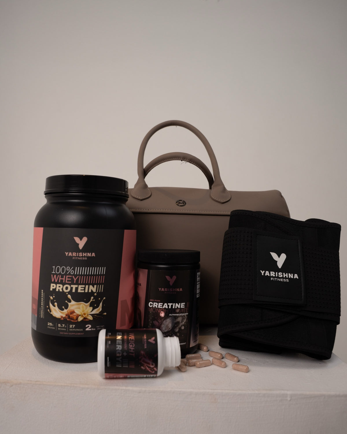 100% Whey Protein, 100% Creatine, Weight Management + Energy and the Yarishna Waist Trainer next to a gym bag