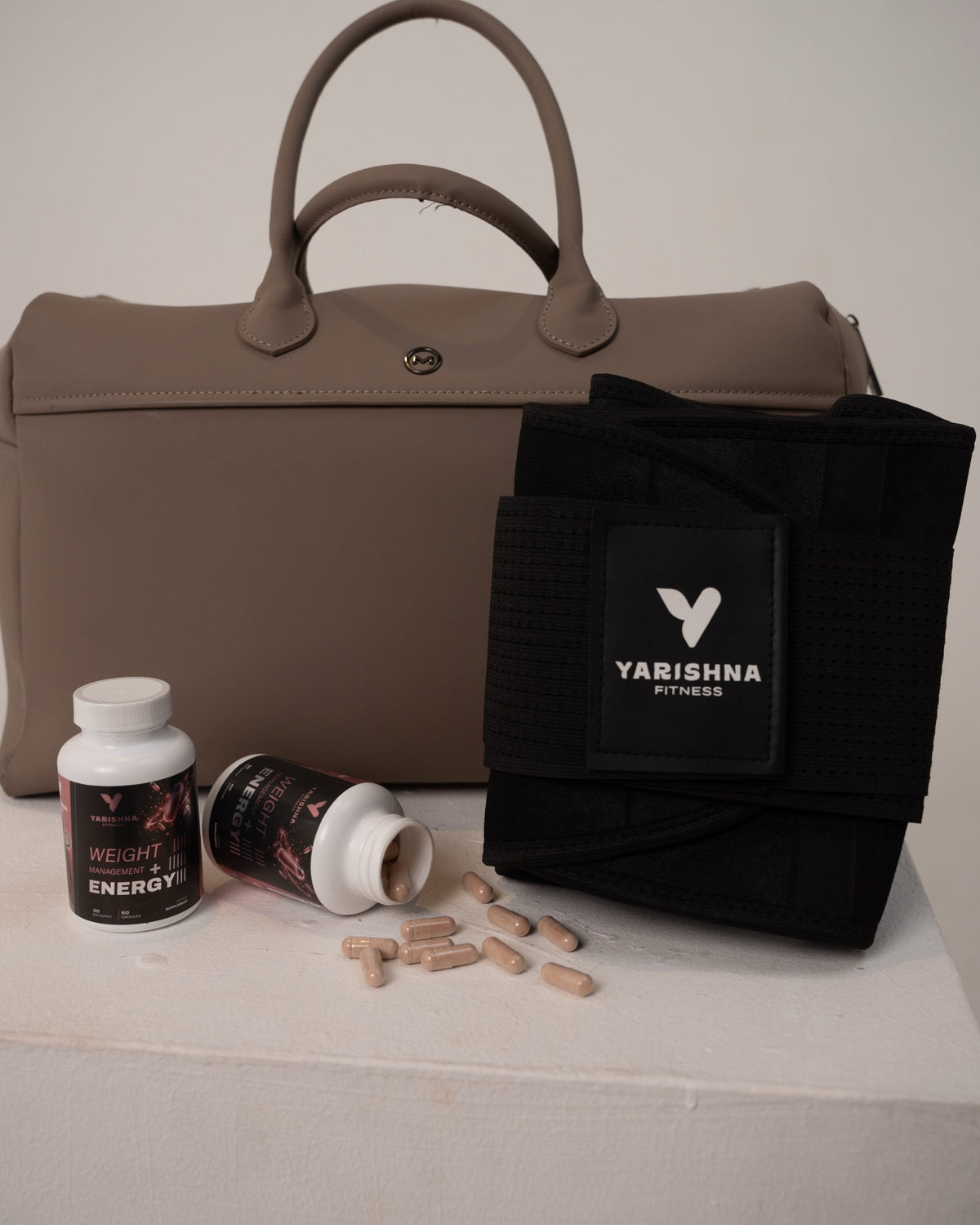Yarishna Waist Trainer and Weight Management + Energy capsules next to a gym bag