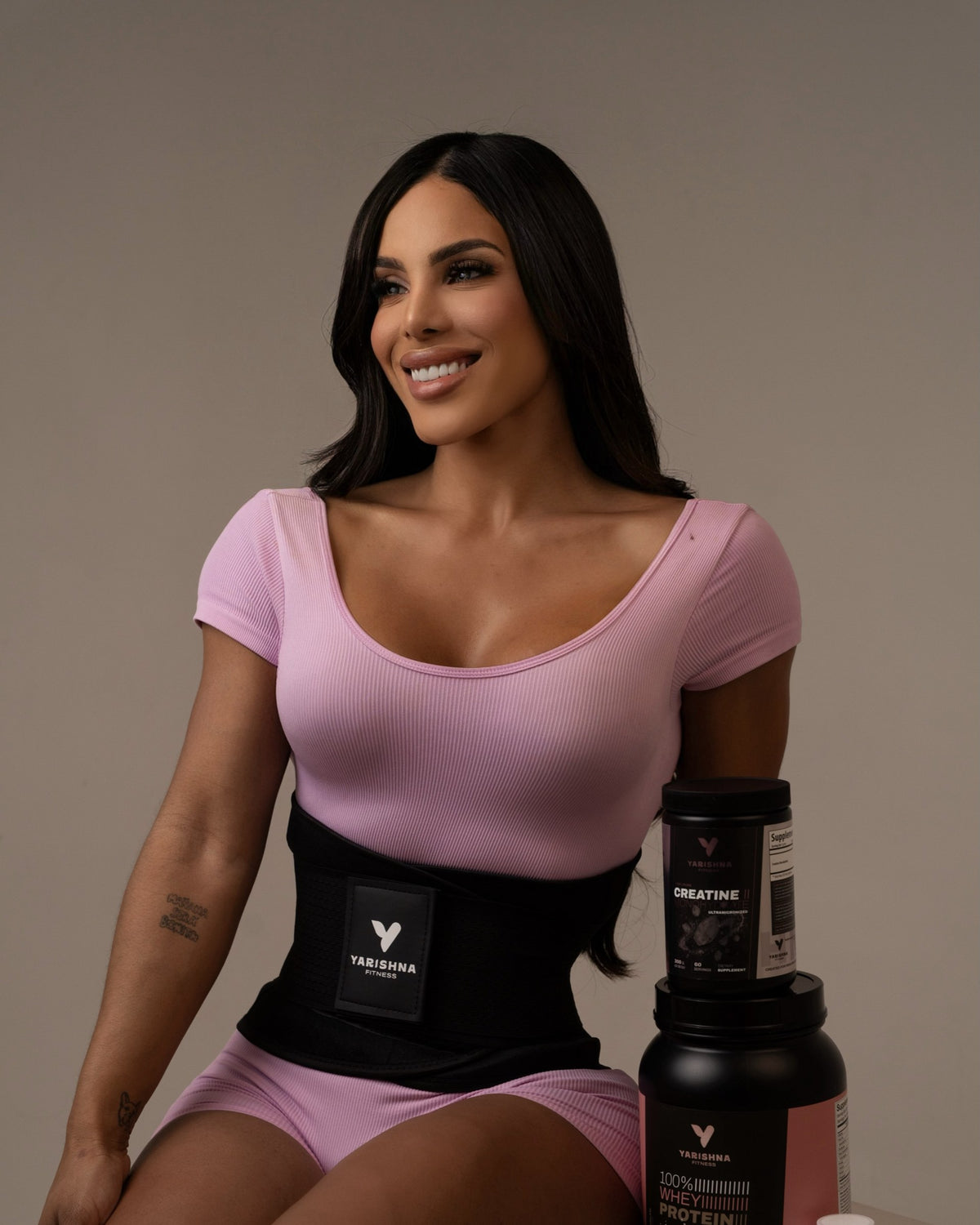 Yarishna Ayala wearing the Yarishna Waist Trainer next to the protein, creatine and Weight Management + Energy